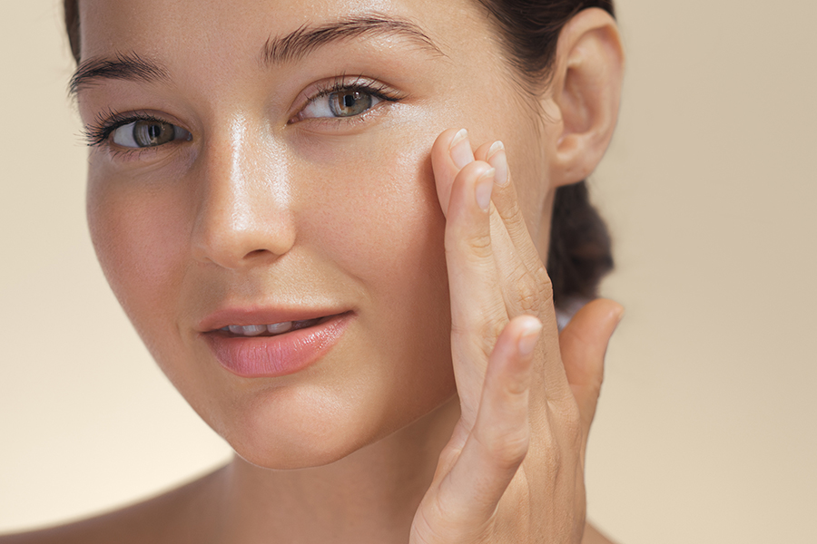 Skincare. Woman with beautiful face touching healthy facial skin.