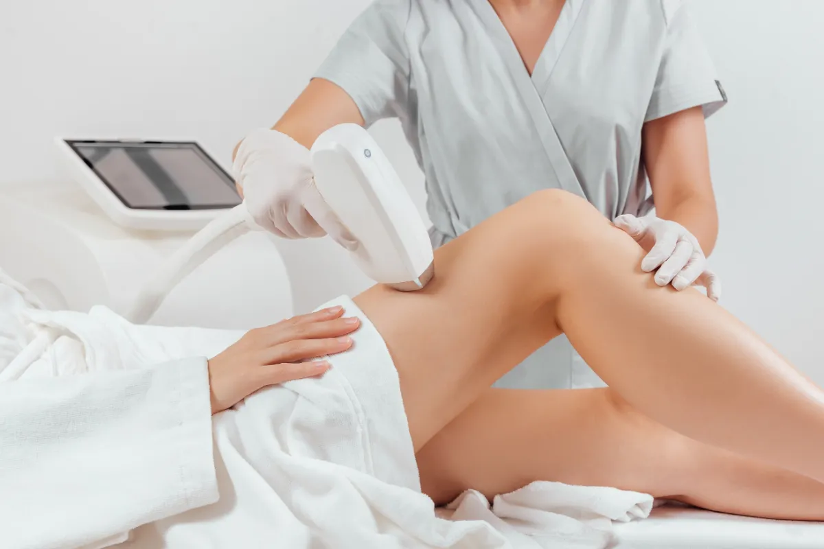 specialist doing hair removal procedure on leg