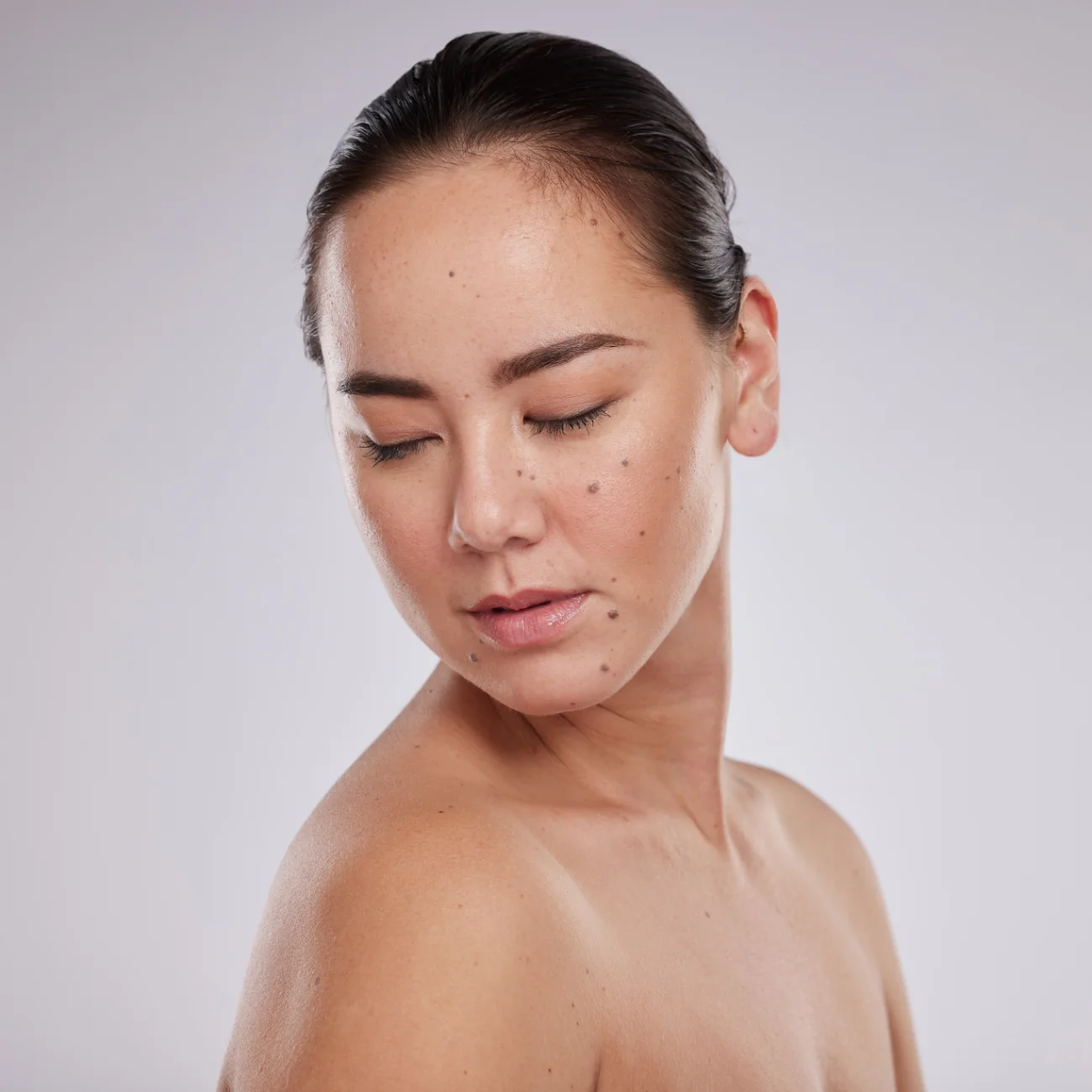Aesthetic asian model person with makeup, mole and luxury facial self care for health and wellness on grey background