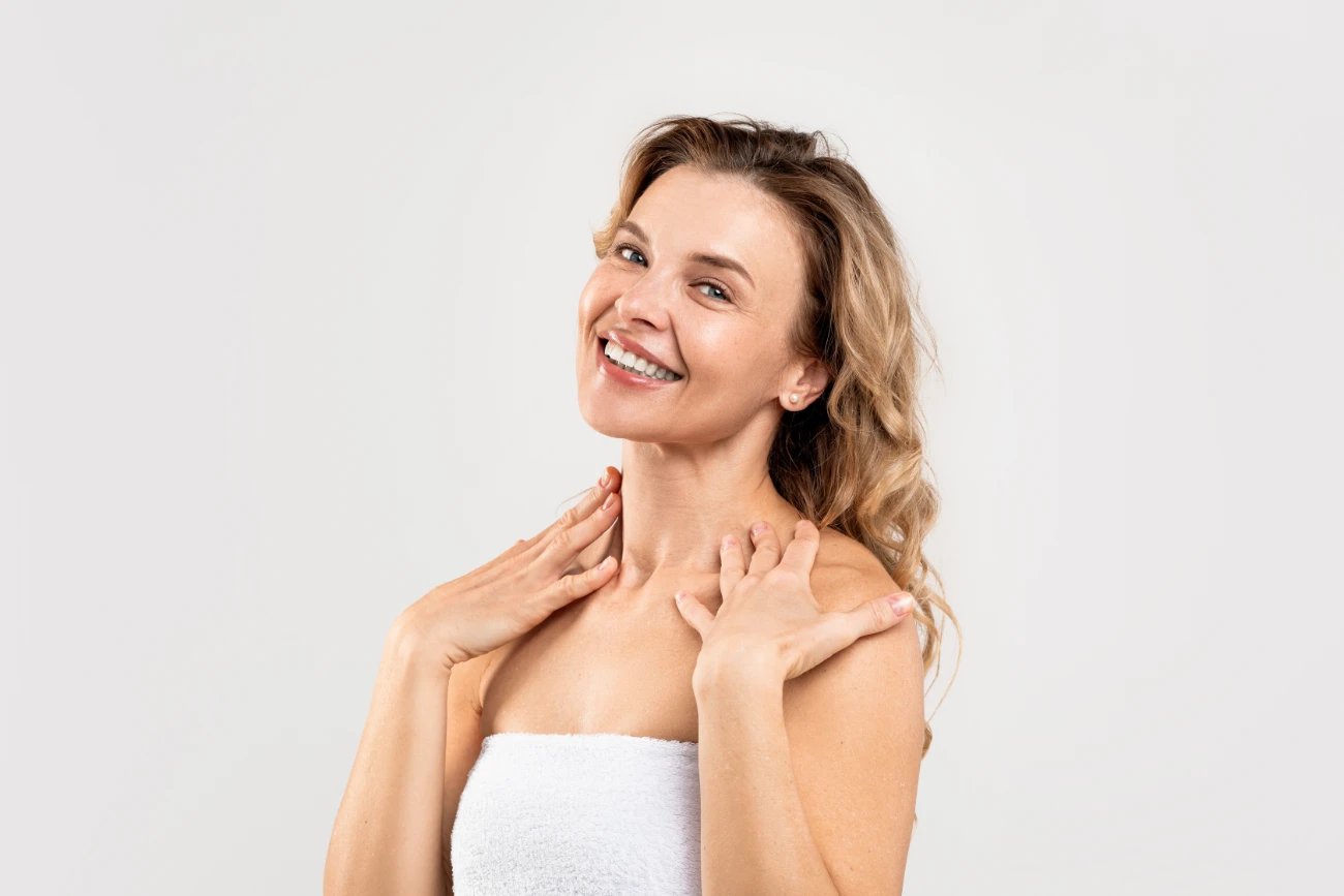 Attractive Middle Aged Female Wrapped In Towel Posing On Light Studio Background embrace rf featured image