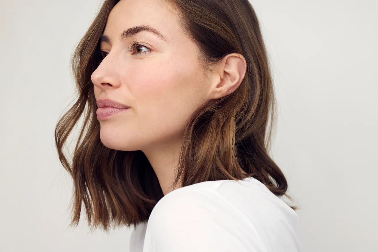 Beautiful natural brunette woman, smiling and looking to the left. earlobe repair featured image