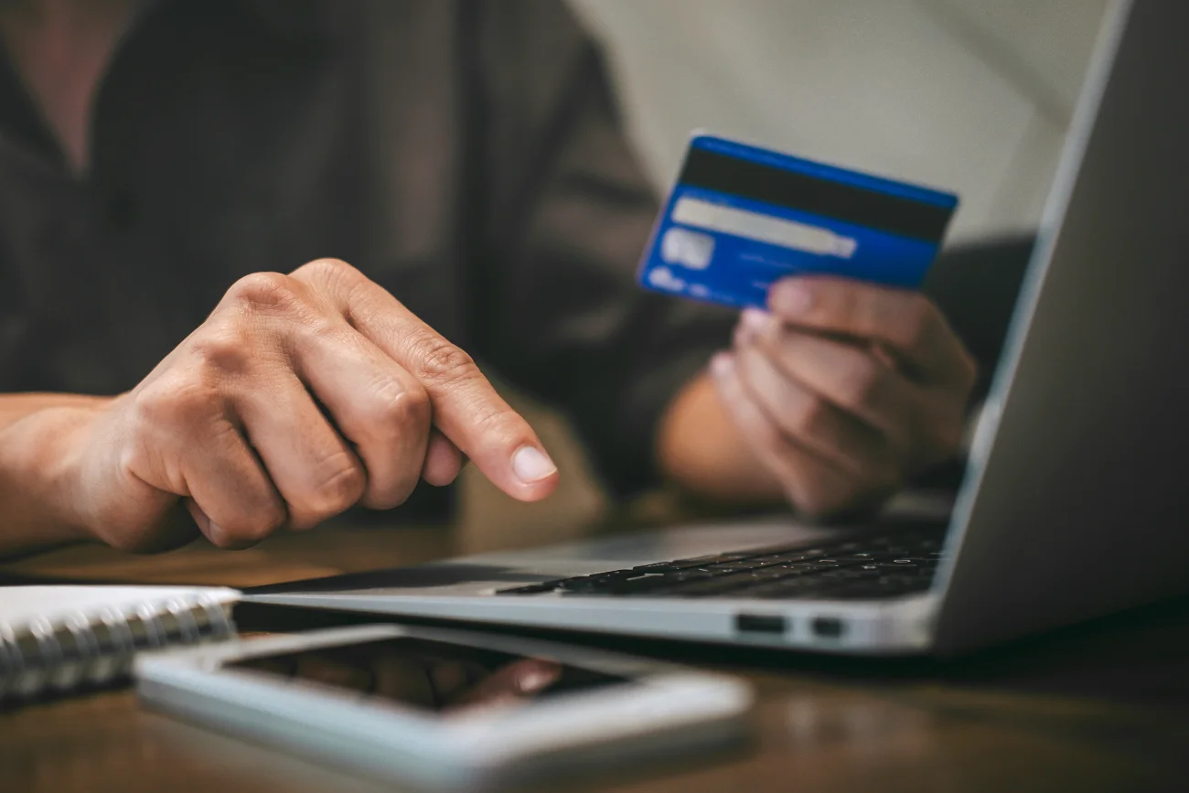 Businessman holding credit card and typing on laptop for online shopping