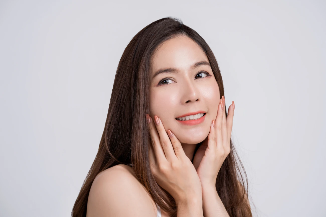 Portrait of an attractive young woman with perfect skin looking out alone over a white background.volbella treatment