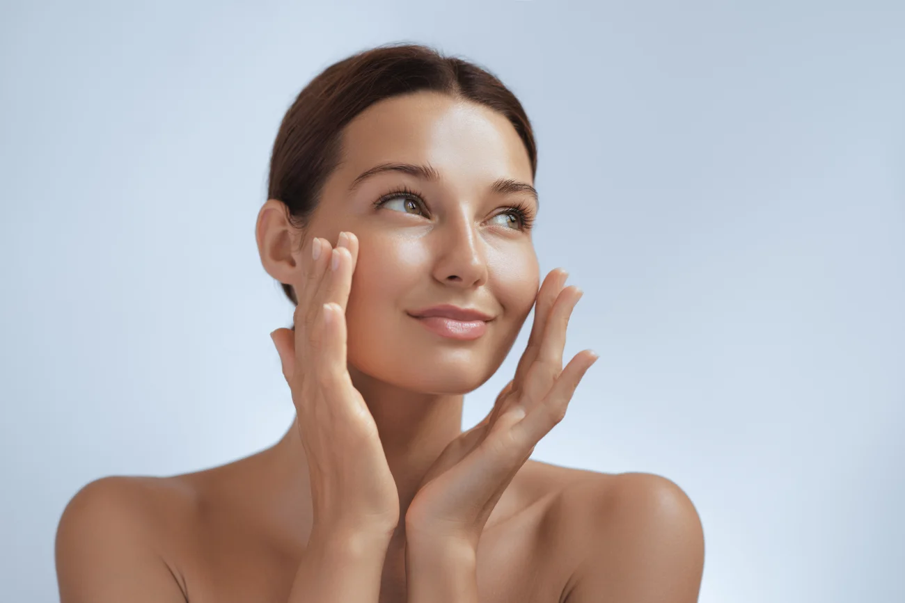 Skincare. Woman with beautiful face touching healthy facial skin.