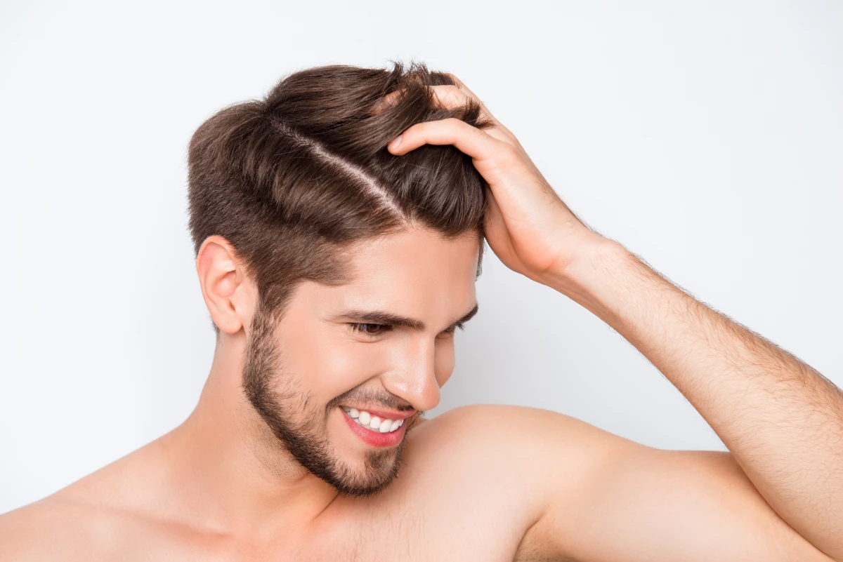 male looking down with fingers through hair