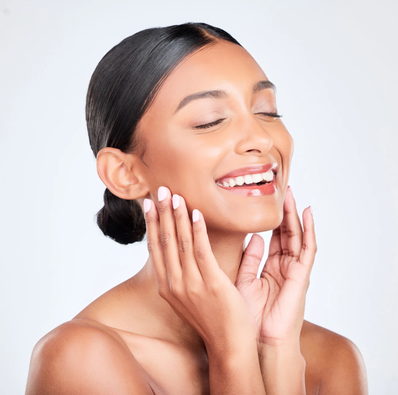 smiling indian woman with perfect skin and hands on face kybella featured image