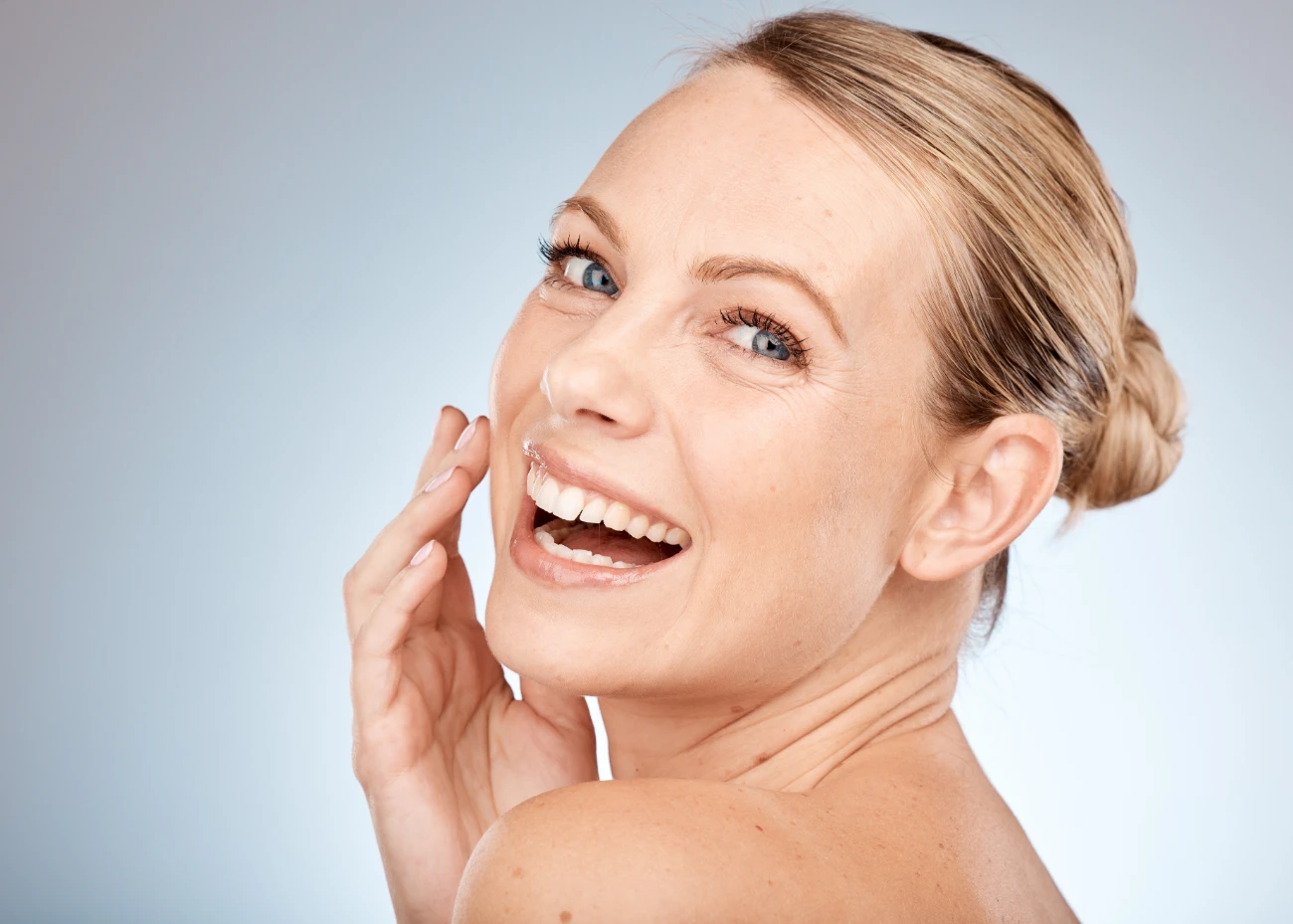 smiling middle aged woman with glowing skin sculptra treatment