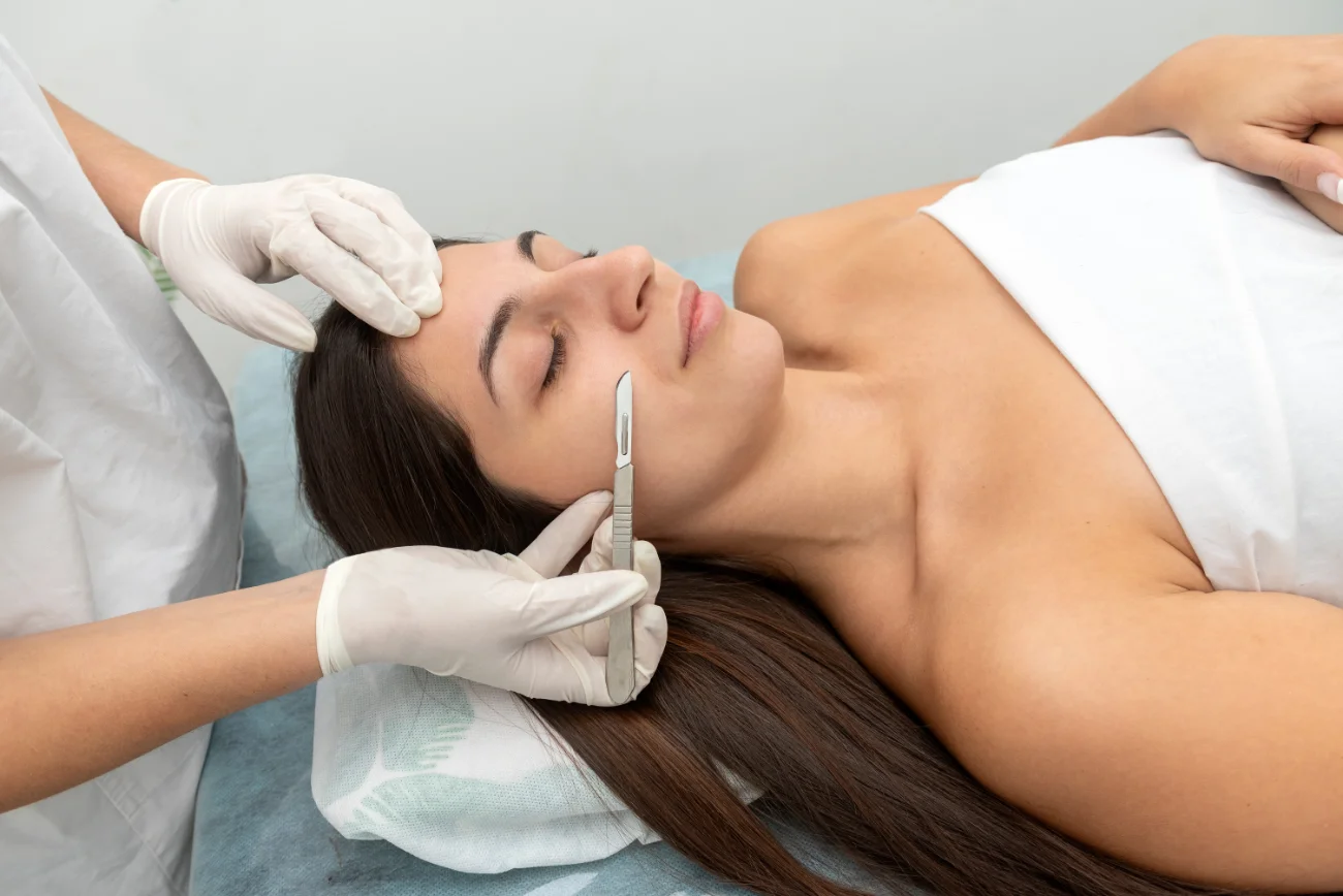 young woman in a beauty center performing a beauty treatment for the skin of the face with the dermaplaning technique