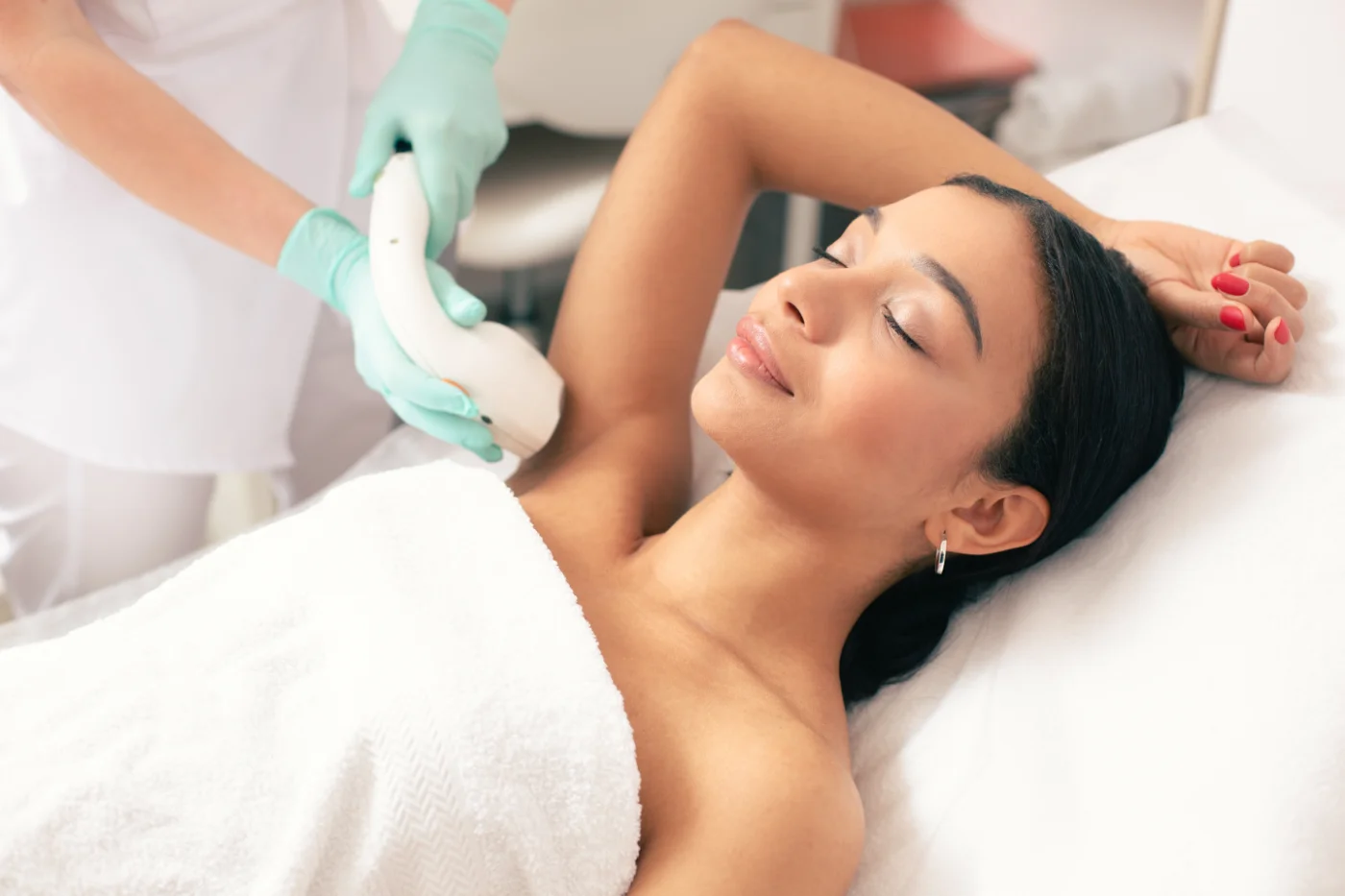 Smiling woman undergoing laser hair removal on her armpit